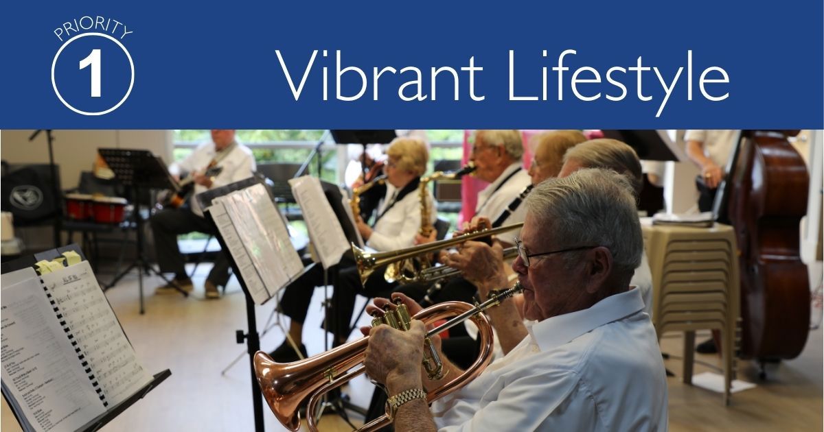 Musicians playing while reading their sheet music inside a community room. Title Priority 1: Vibrant Lifestyle